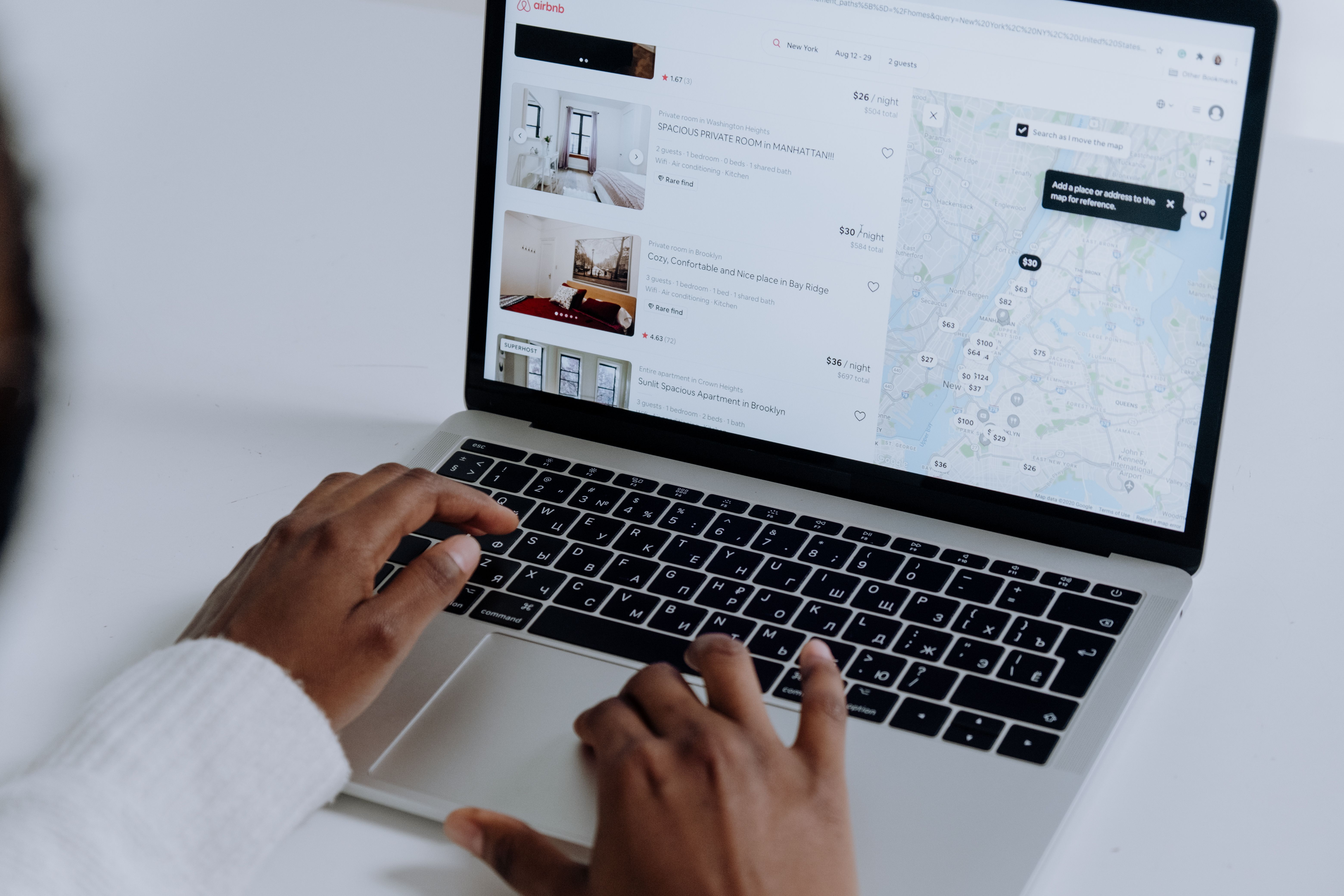 Traveler searching accommodation options on a laptop, representing the moment a direct-booking banner competes with OTAs.